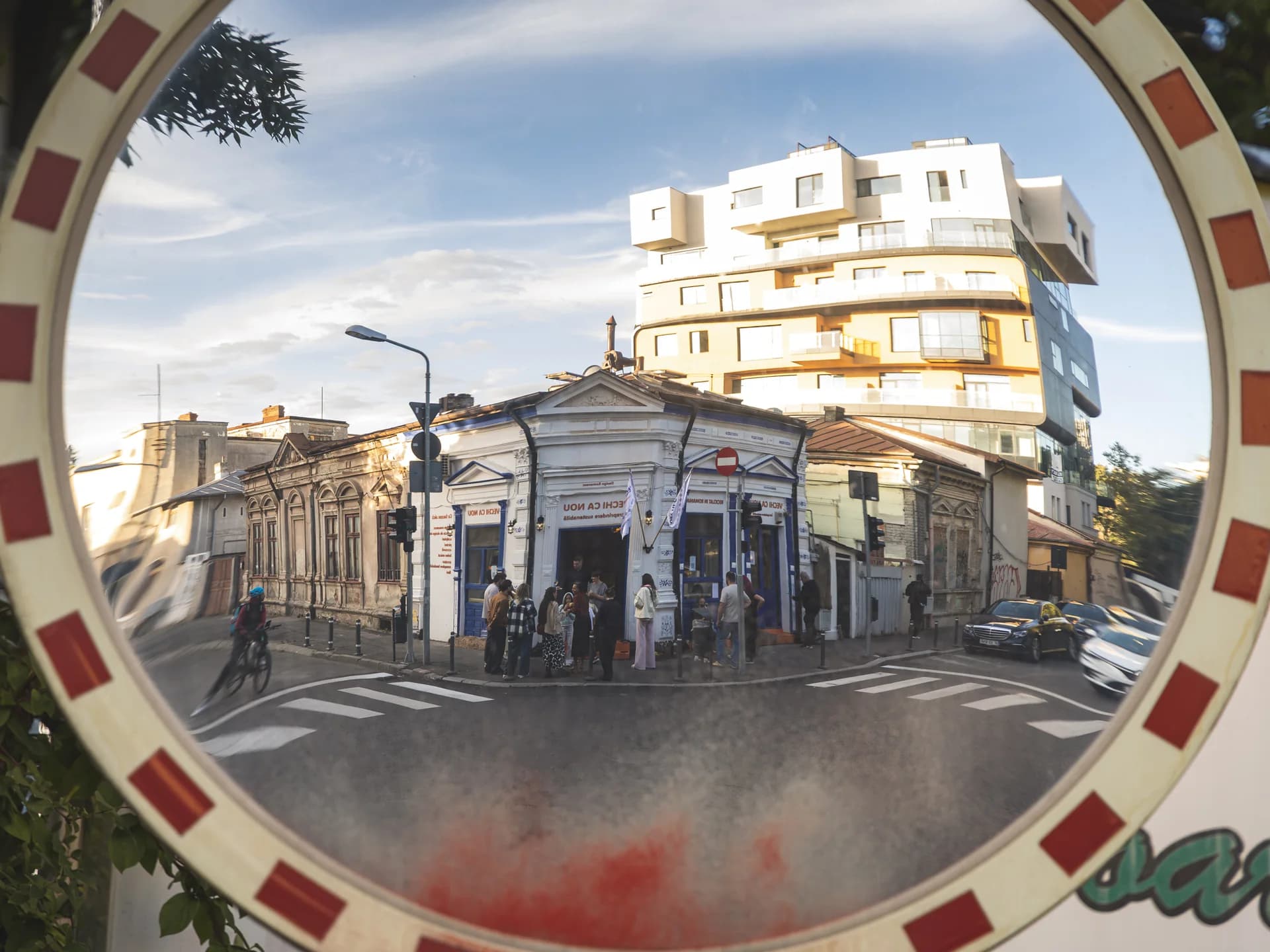 Clădirea galeriei reflectată într-o oglindă stradală.